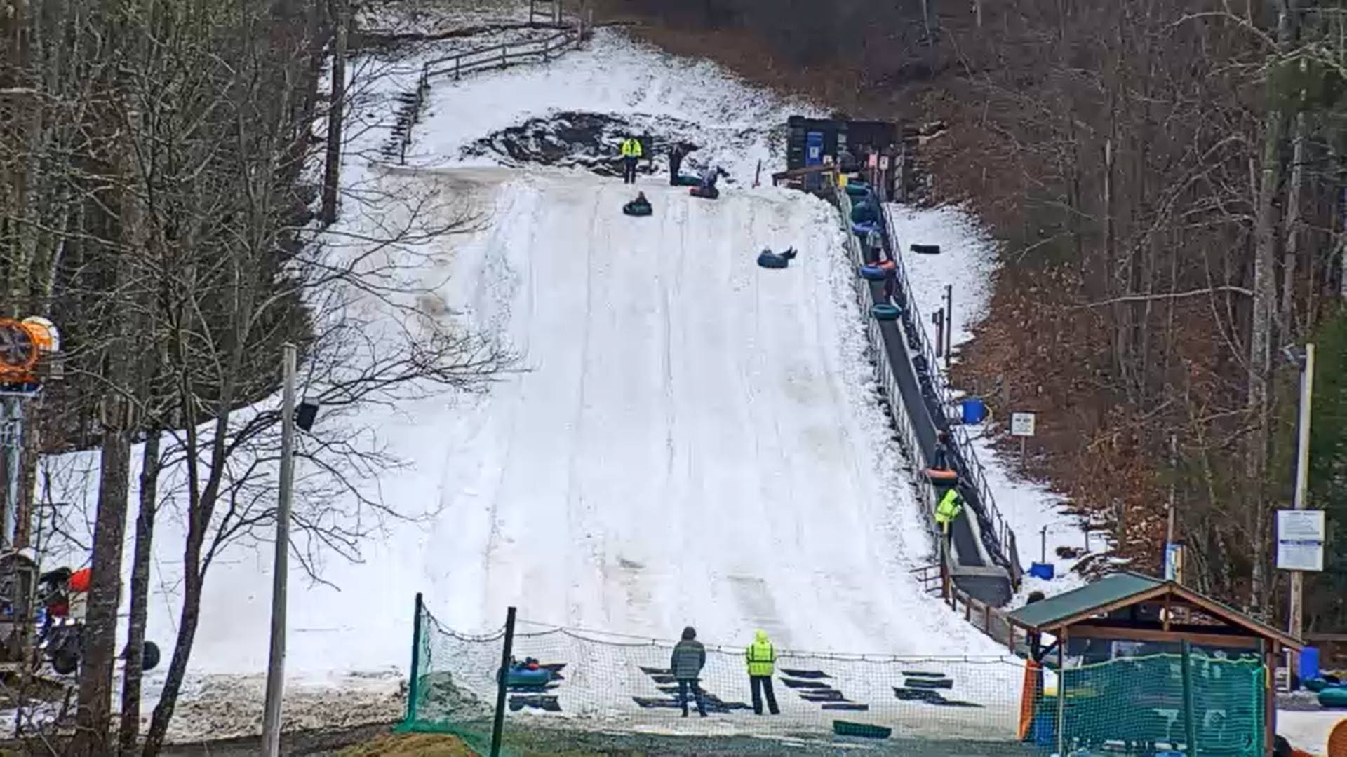 Frozen Falls Tube Park Sapphire NC A view of the snow tubing slopes from below, covered with snow.