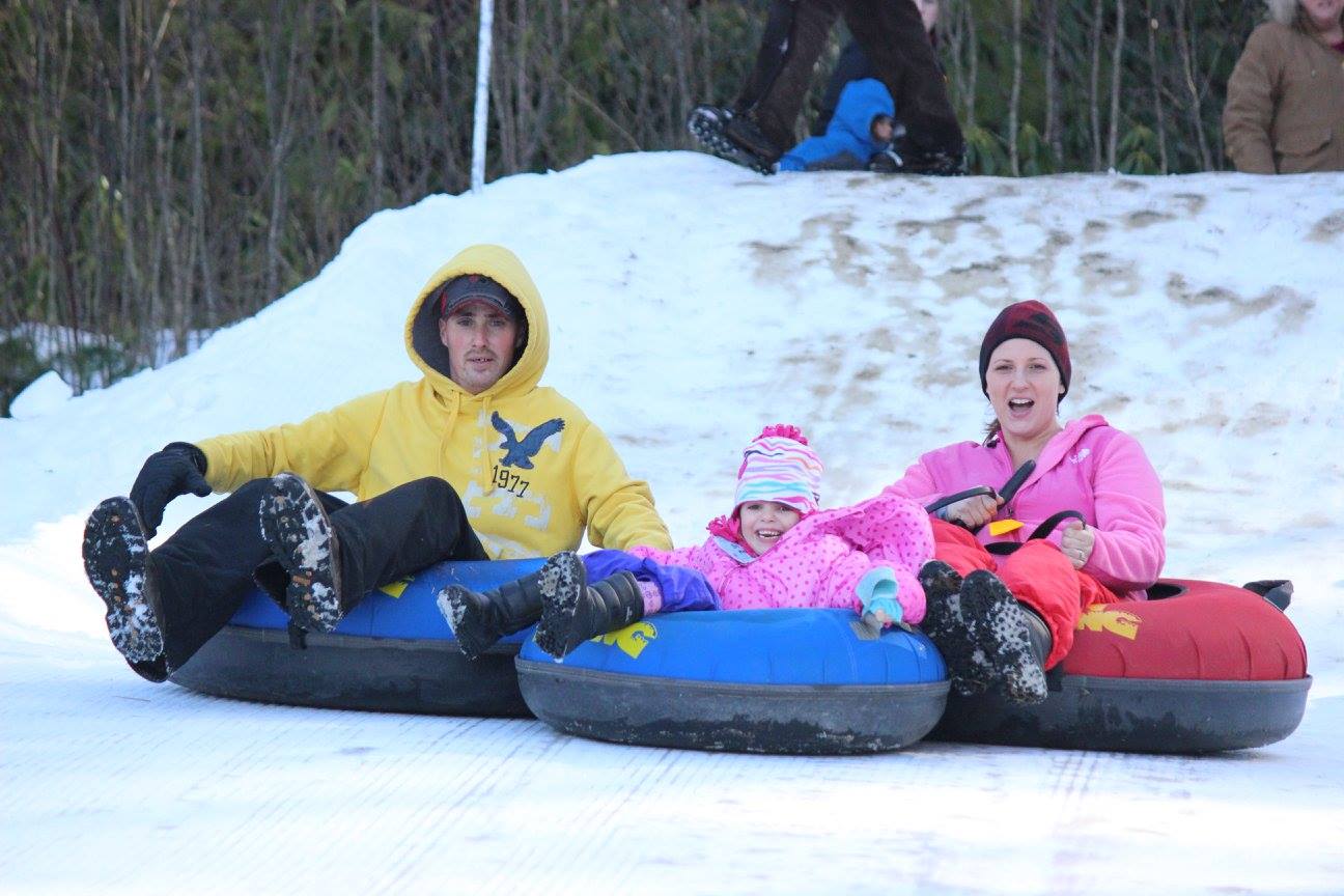 Jonas Ridge Snow Tubing Family enjoys snow tubing down the slopes at Jonas Ridge Snow Tubing