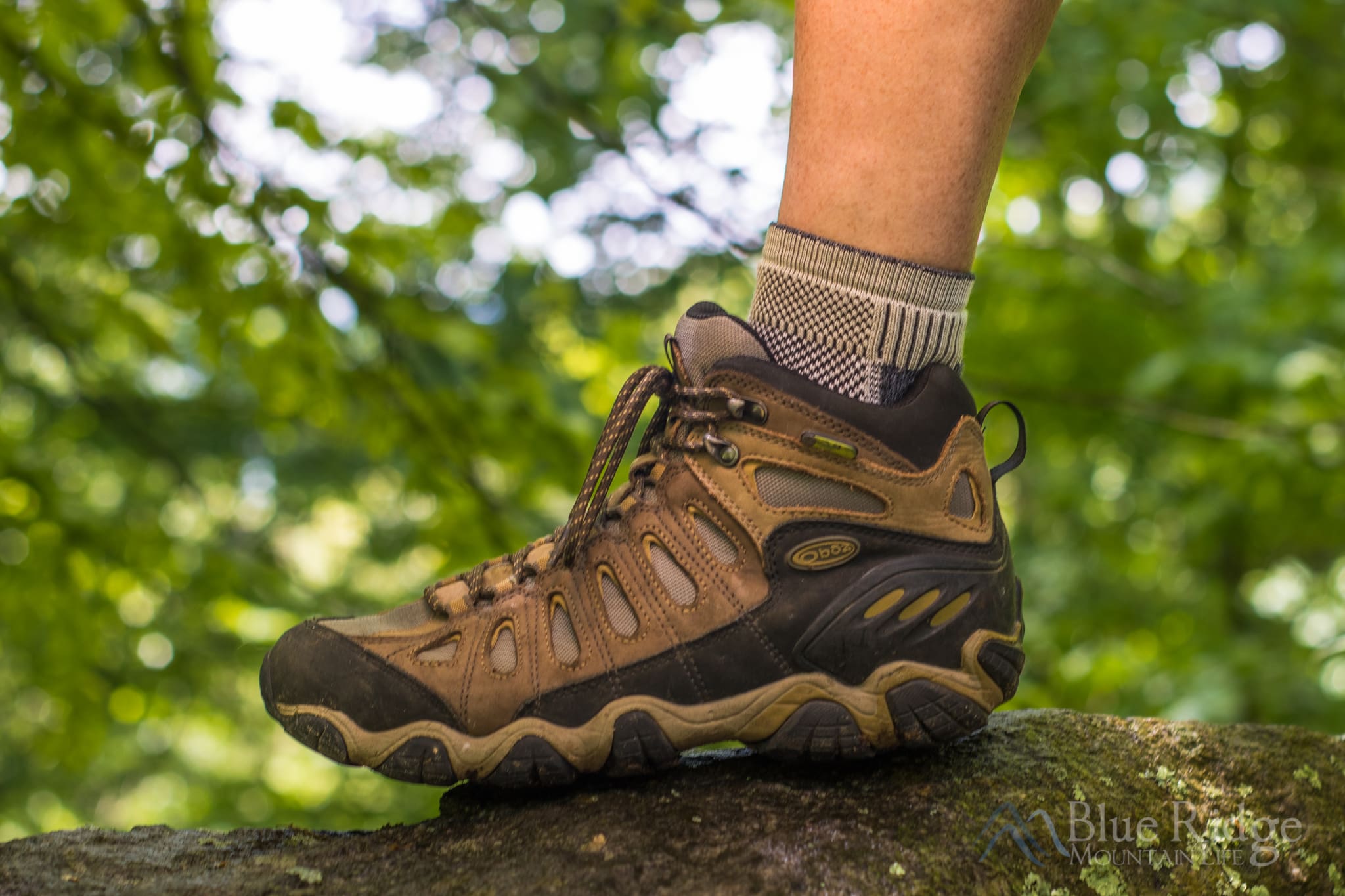 Hiking boots in the woods with hiking socks showing