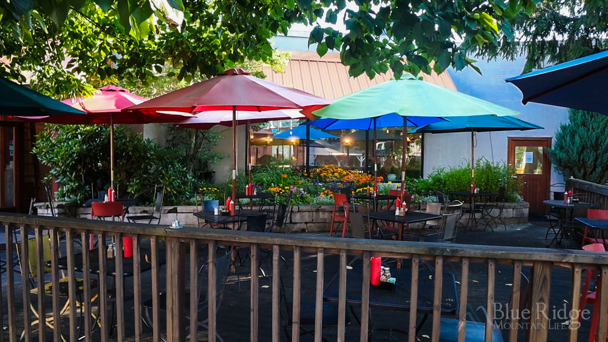 Outdoor Patio at Melanie's In Boone NC Outdoor Patio at Melanie's with metal tables topped with Red and Blue Umbrella covers