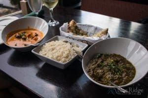 Photo of our food which was Chicken Tiki Masala, Basmati Rice, and Saag Paneer.  The dishes are in bowls on our table with Garlic Naan