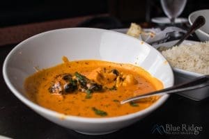 Close-up of Chicken Tiki Masala in a white bowl showing the orange colored sauce.