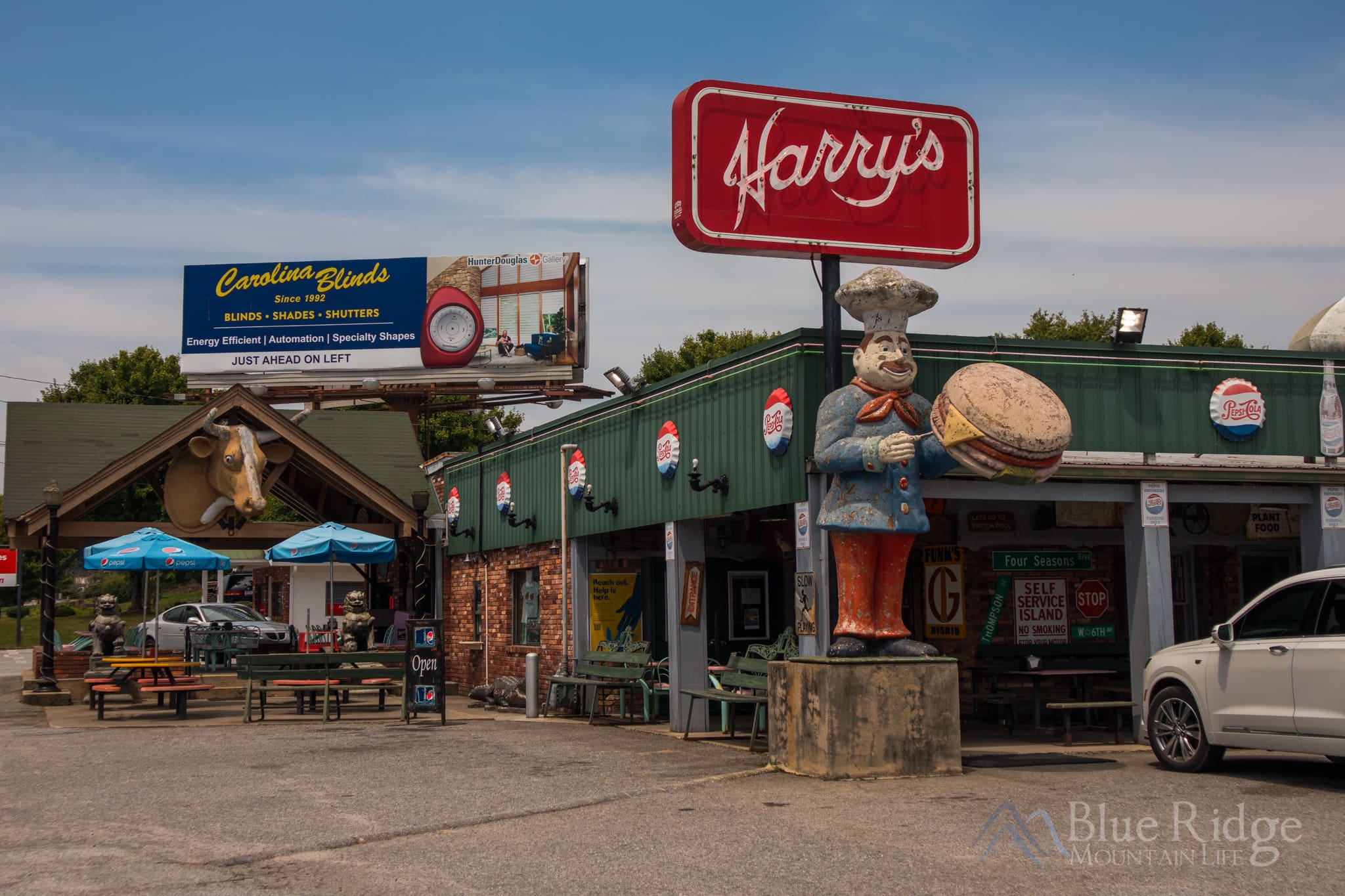 Piggy's Ice Cream Hendersonville NC Photo of the outside of Piggy's Ice Cream with the parking area, a car, and the big red Harry and Piggy's sign.