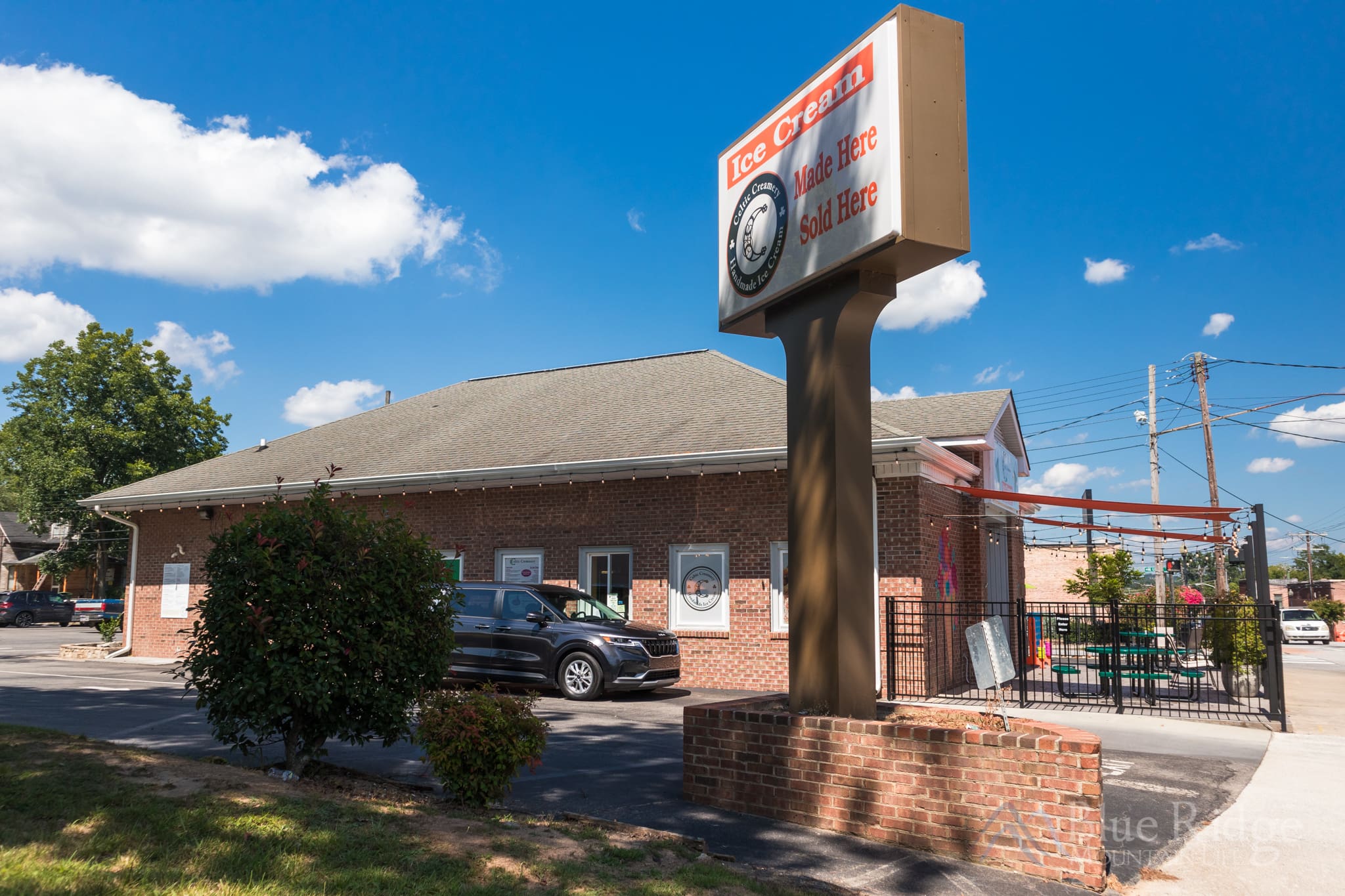 Celtic Creamery Hendersonville NC Outside view of Celtic Creamery in Hendersonvill NC, showing the brick building, their sign, and a car going through the drive thru.