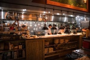Photo of the open kitchen at Shine in Hendersonville NC, with workers cooking and prepping the diner orders.