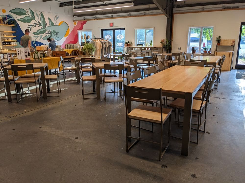 Hatchet Coffee Boone NC Interior of Hatchet Coffee with large and small wooden tables and chairs.