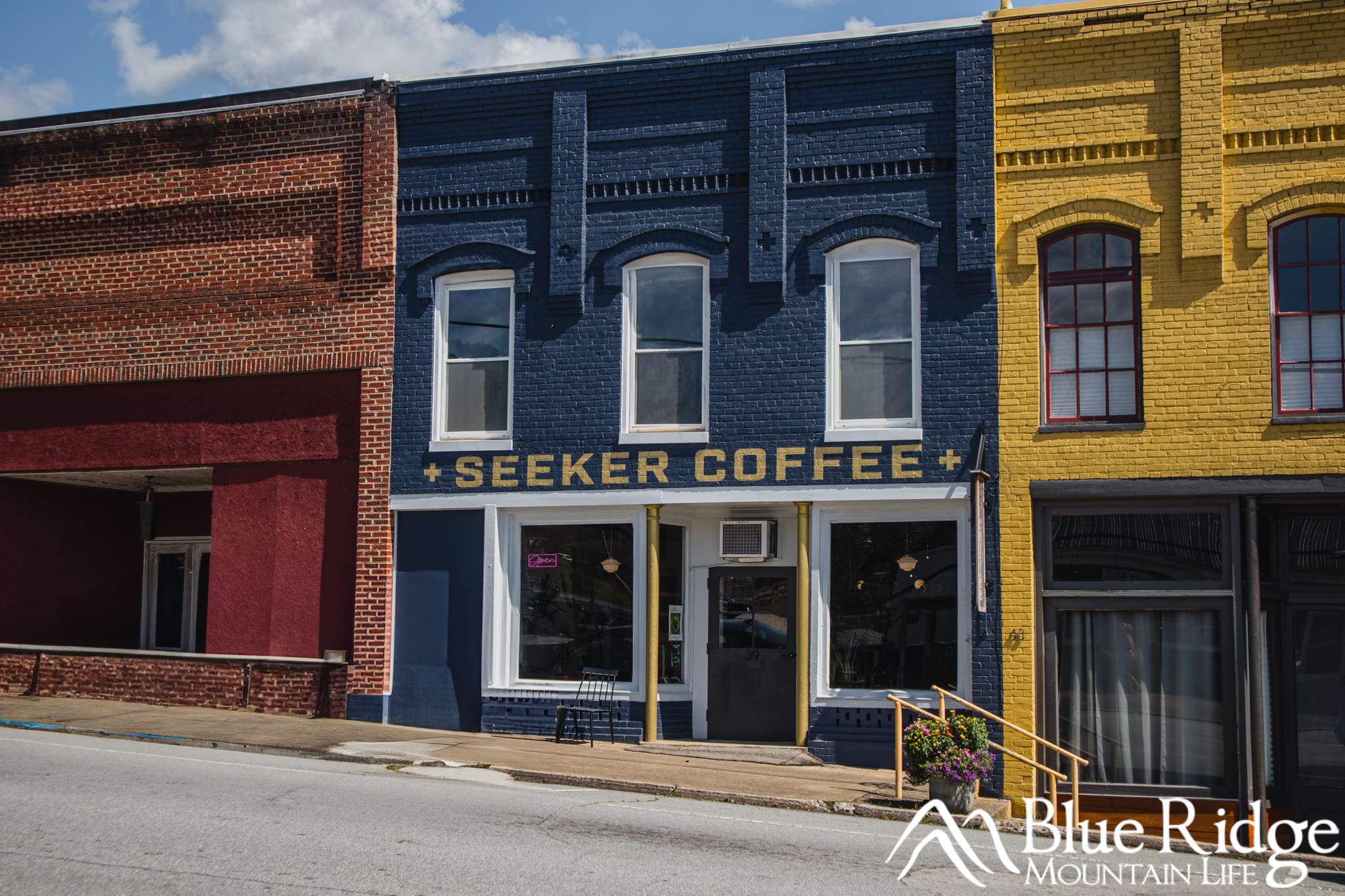 Seeker Coffee in Old Fort NC Exterior of Seeker Coffee, one of the hold and historic buildings in downtown Old Fort. The building is dark blue with white trim and a sign saying Seeker Coffee above the door.