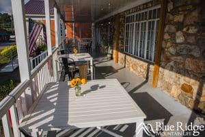 Photo of the front porch of the Davis Country Store with outdoor seating and yellow flower arrangements on the tables.