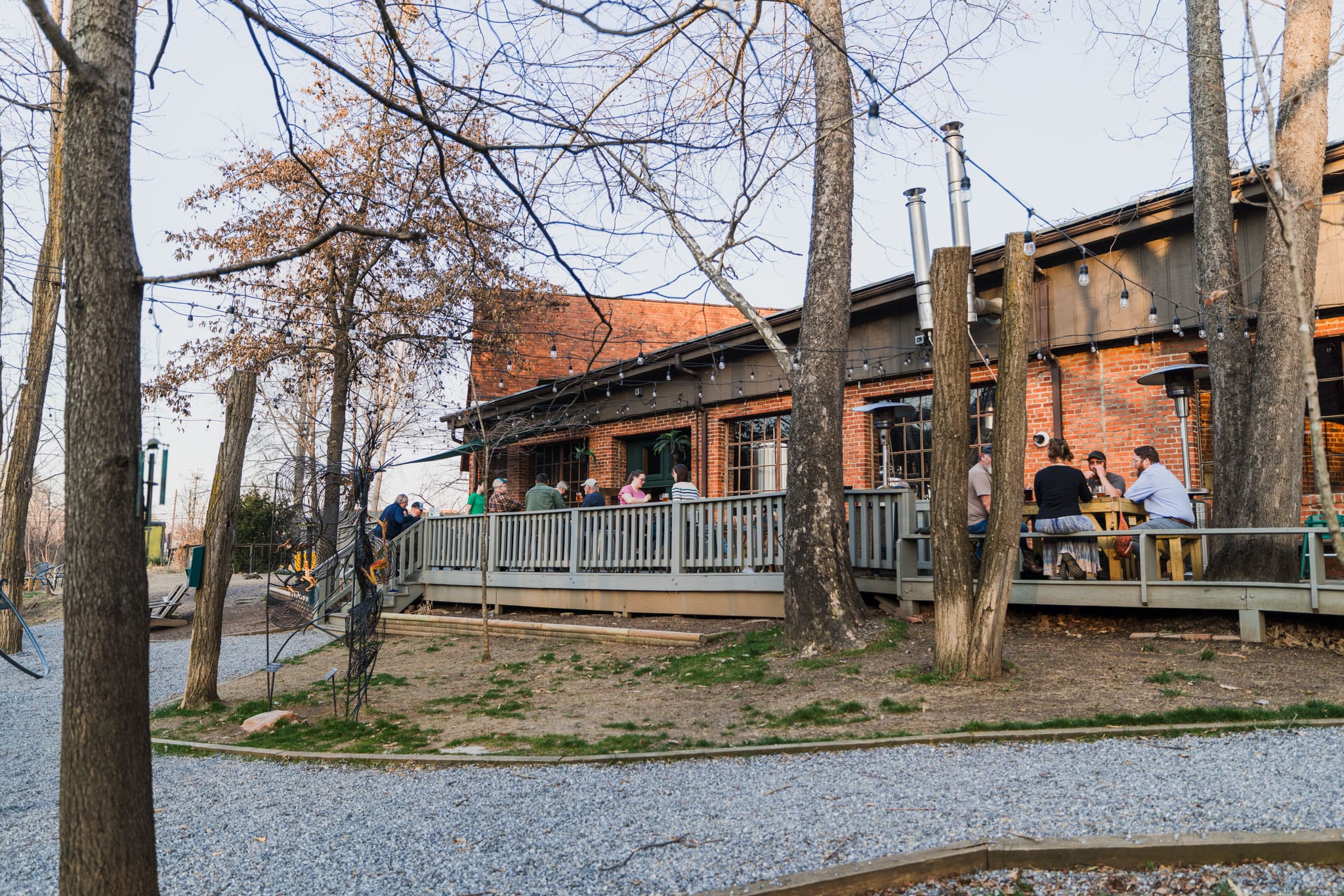 Frog Level Brewing Outdoor Seating Area Frog Level Brewing Outdoor Seating Area, showing deck and gravel walkways behind the stone building and creek side.