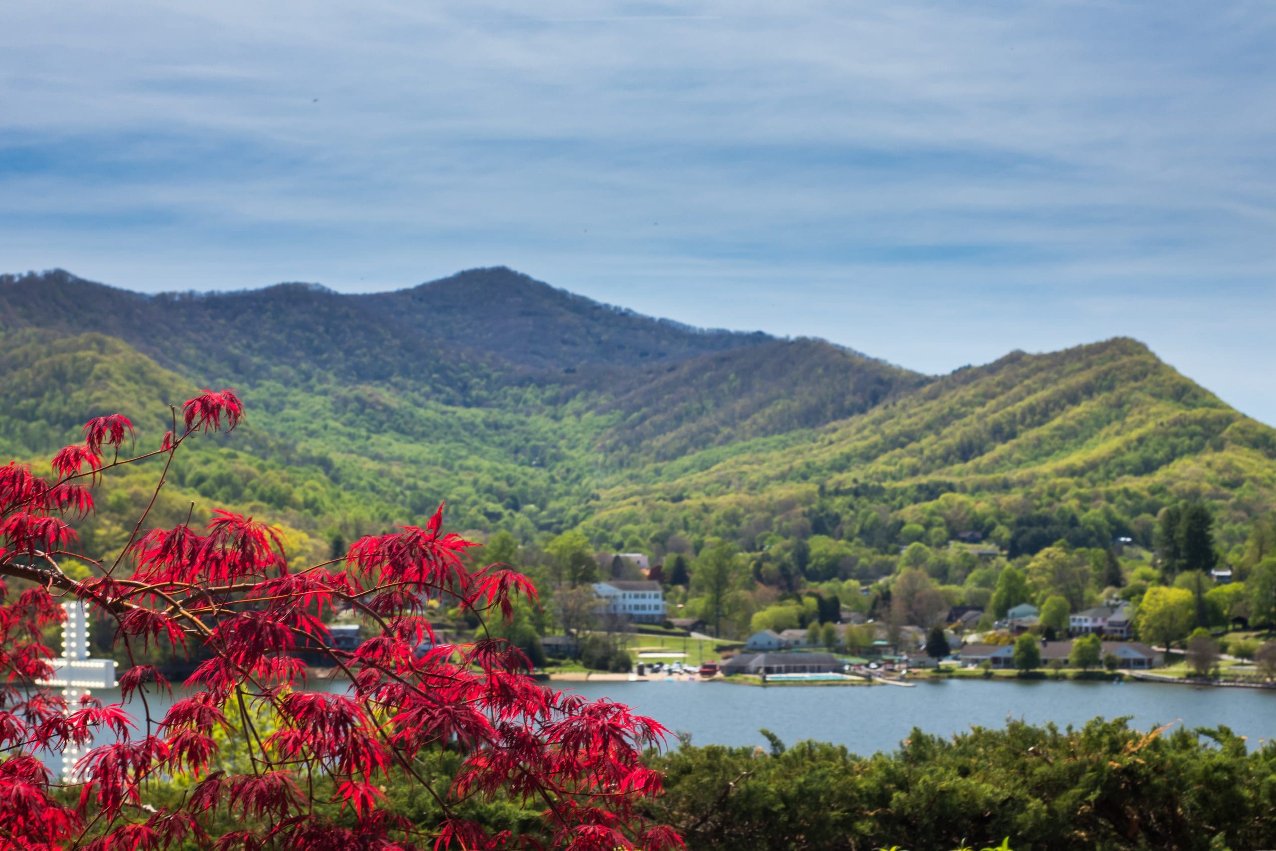 Lake Junaluska NC Lake Junaluska NC photo showing a bright red maple tree in the foreground, with the lake and tall green mountains behind it.