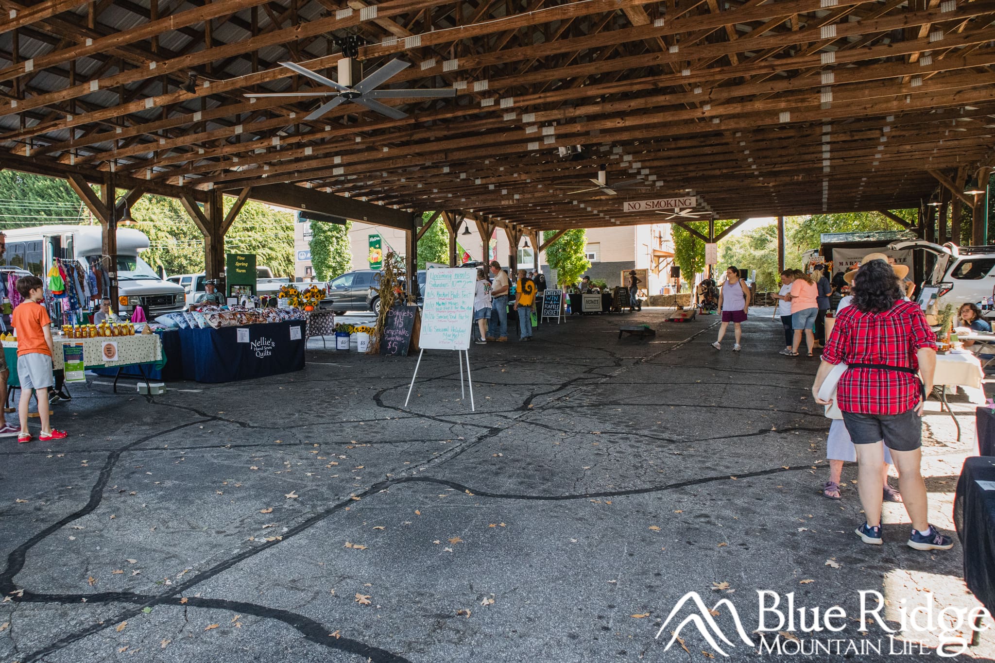 Marion Farmer's Market Photo of the Farmer's Market under a covered roof, with different vendors all around, and a live music performer in the distance.