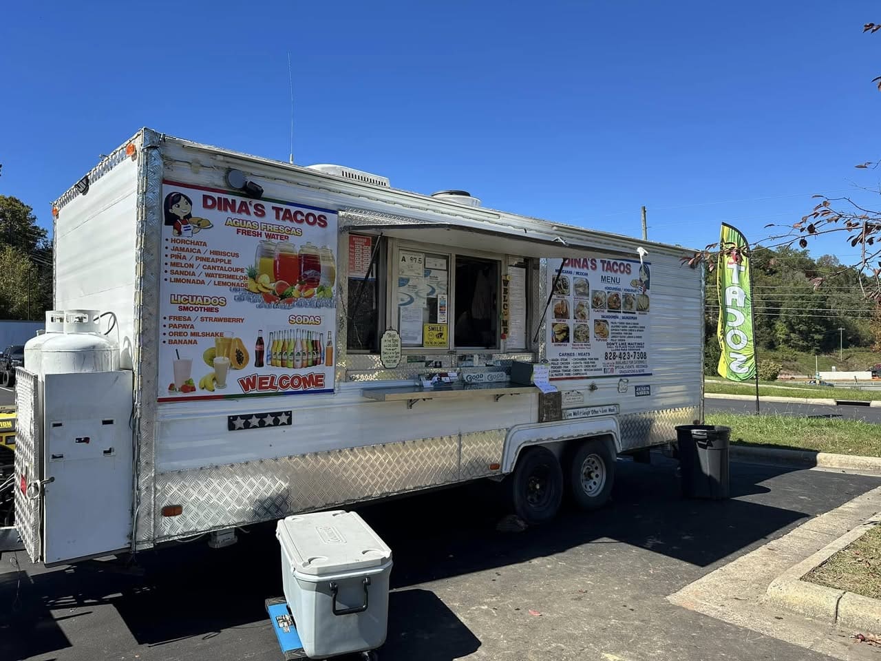 Dinas Tacos Waynesville NC Photo of Dinas Tacos which is a white food trailer with the menu on the left front.