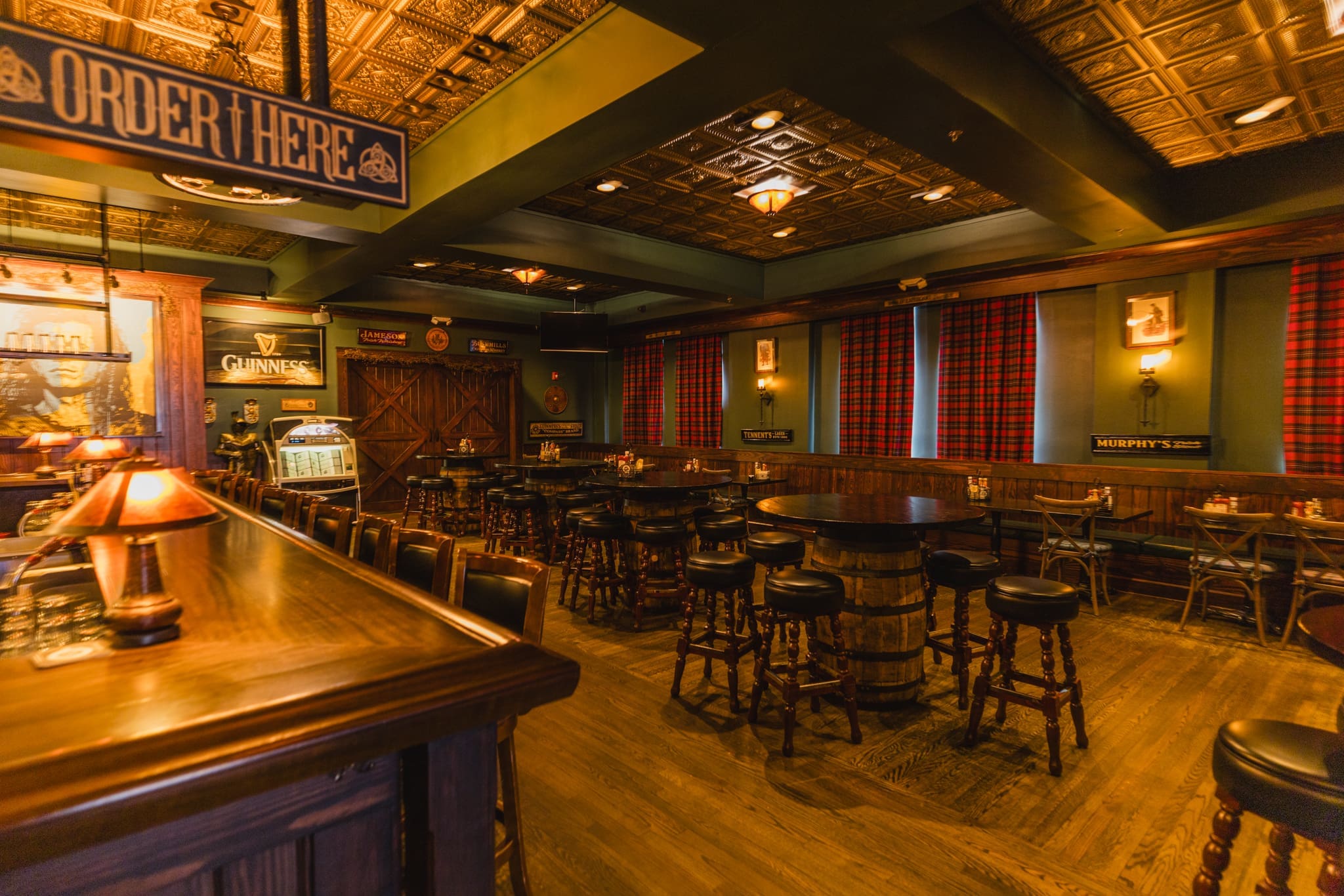The Scotsman Public House in Waynesville, NC Interior photo of the beautiful Scotsman Public House in Waynesville, NC. Photo shows a darker pub like environment with dark wood stain, and burgandy curtains. The photo shows a portion of the bar and dining tables.