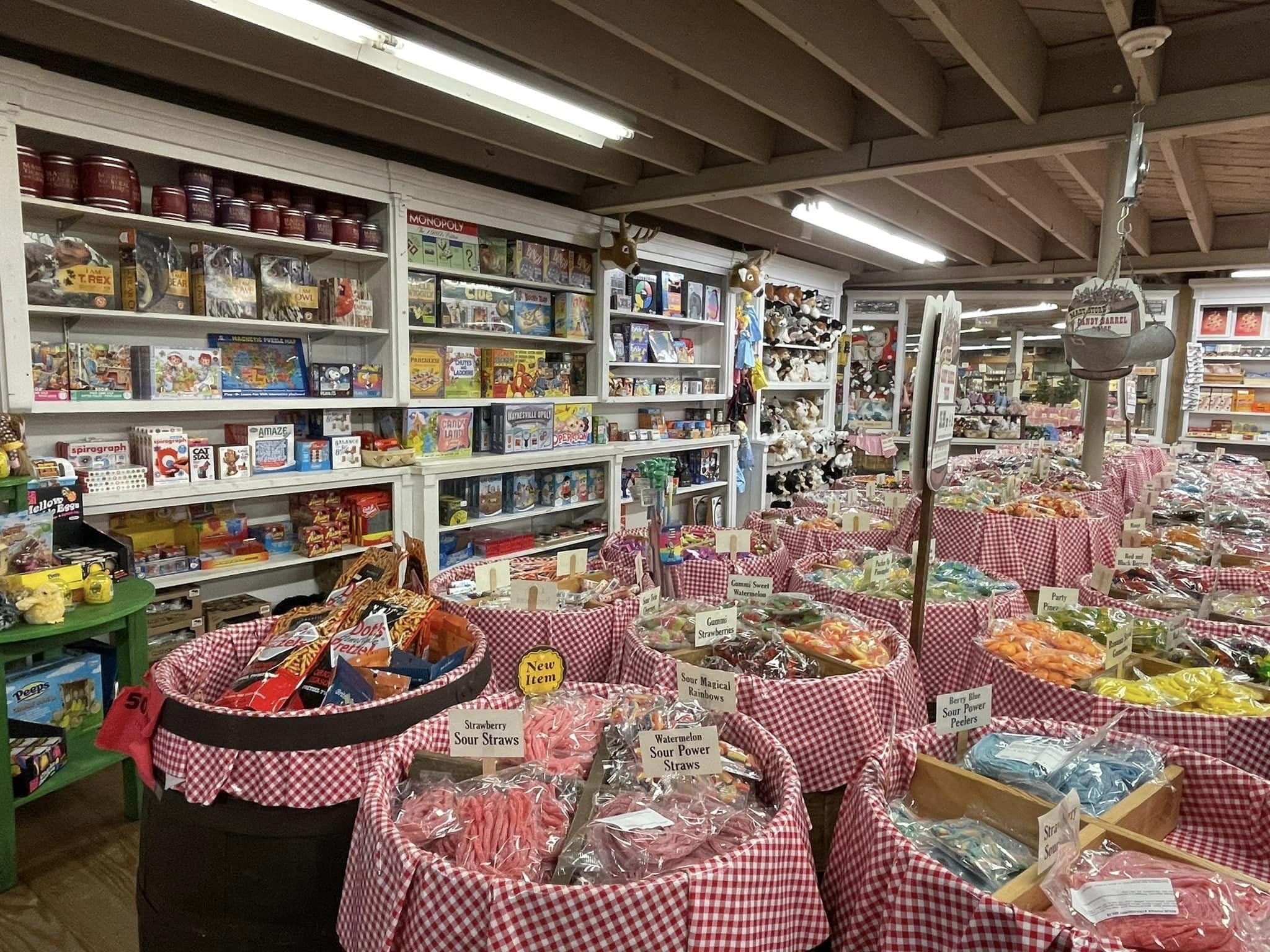 Mast General Store Waynesville NC Photo of the downstairs floor of Mast General Store in Waynesville NC. The photos shows large barrels of candy surrounded by shelves of goods for sale.